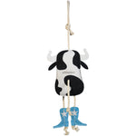 Full back view of the Wiskadero Cow Pie equine boredom buster toy. Highlights the stamped Wiskadero logo on the black and white suede cow head, white suede horns, turquoise cowboy boots with white embroidered stars, pull-through natural rope tail, and top hanging loop.