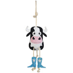 Full front view of the Wiskadero Cow Pie equine boredom buster toy. Highlights the black and white suede cow head with a pink snout, turquoise cowboy boots with white embroidered stars, pull-through natural rope tail, and top hanging loop.