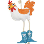 Close-up front view of the Wiskadero What the Cluck toy showing the white and orange suede body, red comb and wattle, pull-through natural rope legs, and turquoise suede cowboy boots with embroidered white stars.